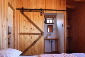 "Ocho Águilas Eco Lodge": Foto del dormitorio de la Cabaña SUITE con puerta corrediza al baño