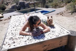 "Ocho Águilas Eco Lodge". Chica y su mascota disfrutando de la cama de cuarzo